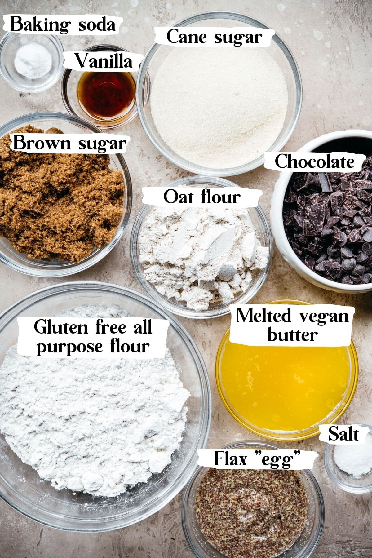 overhead view of ingredients in glass bowls to make vegan chocolate chip cookies with text labels on photo.  