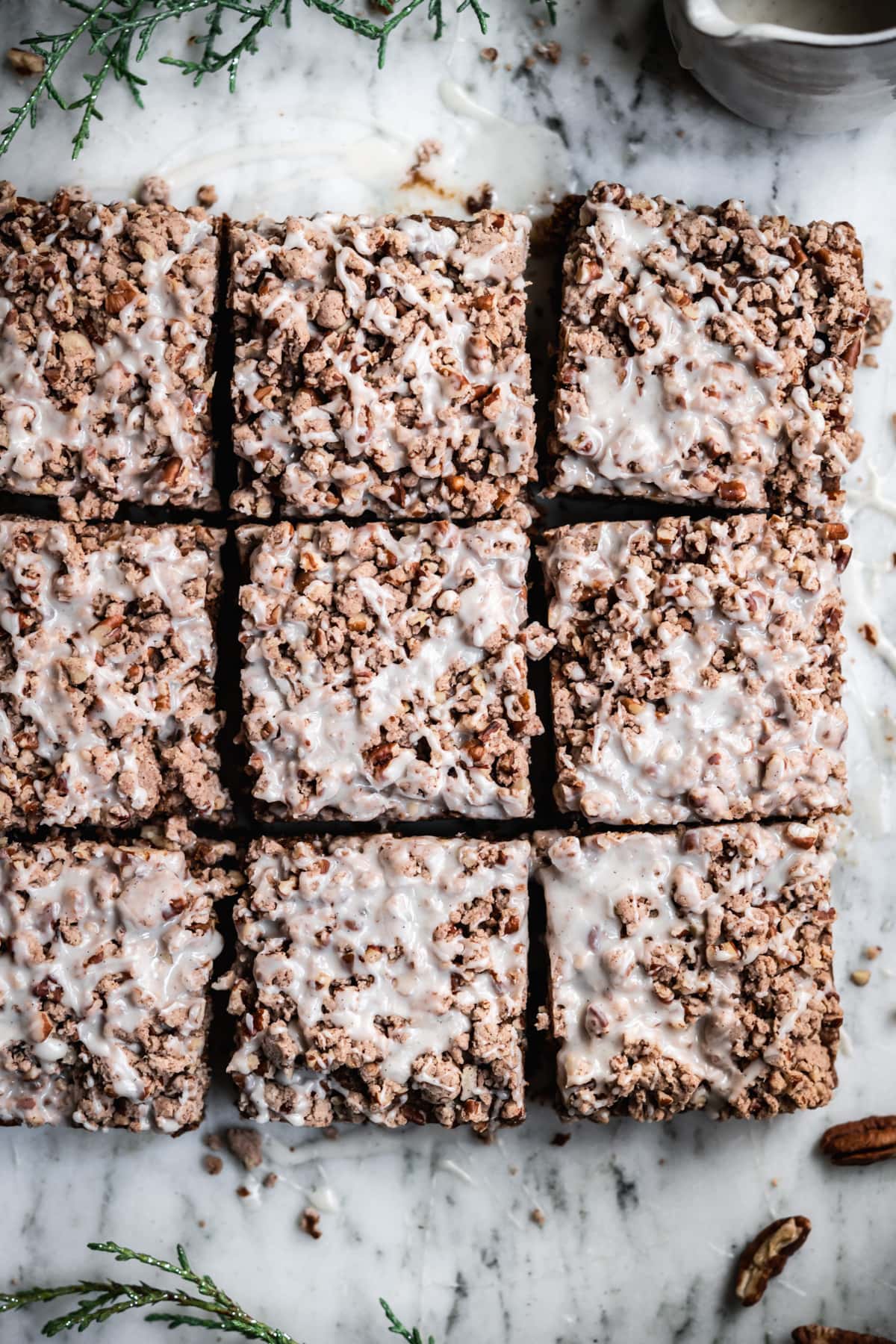 close up overhead view of gingerbread coffee cake with pecan streusel and vanilla glaze. 