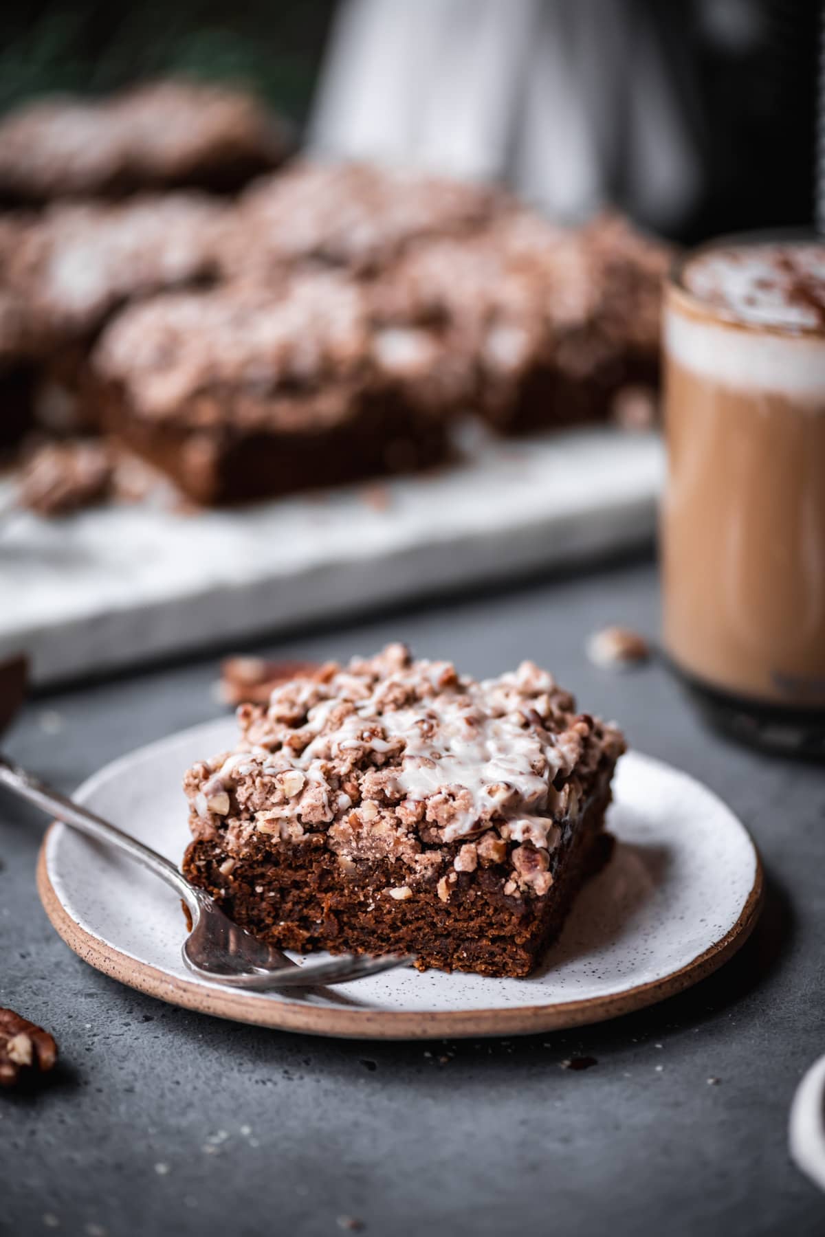close up view of vegan gingerbread coffee cake slice on a small ceramic plate.