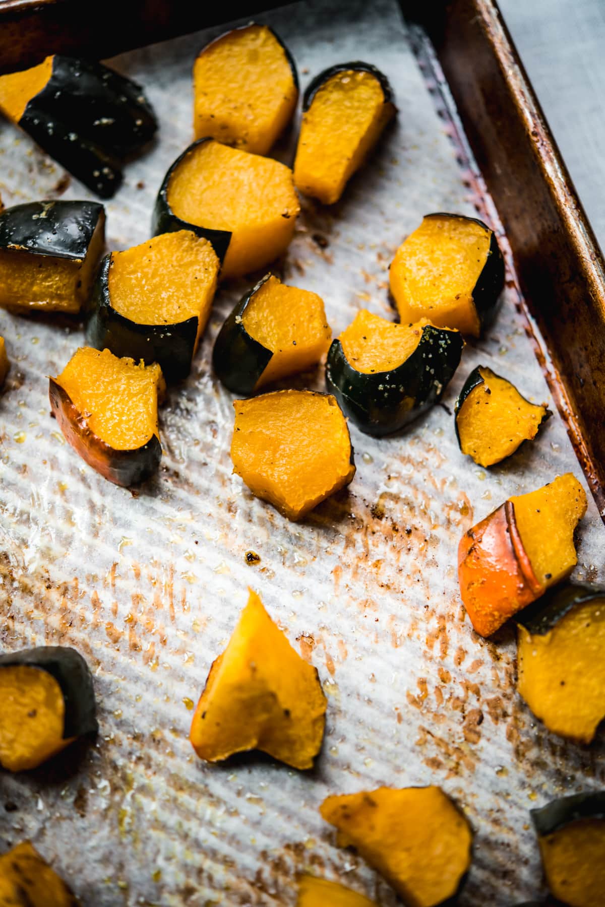 side view of roasted acorn squash on a sheet pan. 