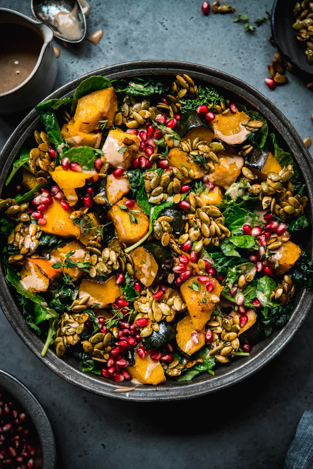 overhead view of roasted acorn squash salad with pumpkin seed brittle and pomegranate.