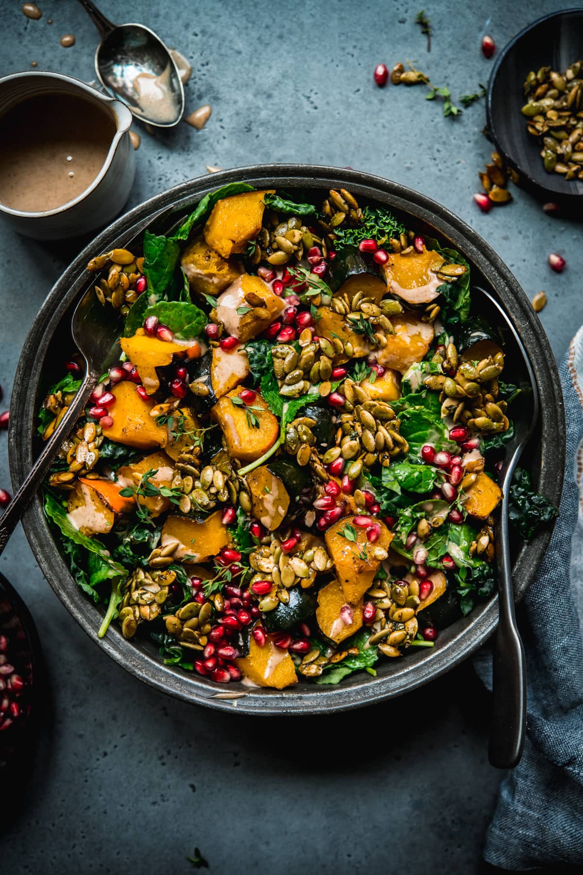 overhead view of roasted acorn squash salad with pumpkin seed brittle and tahini dressing.