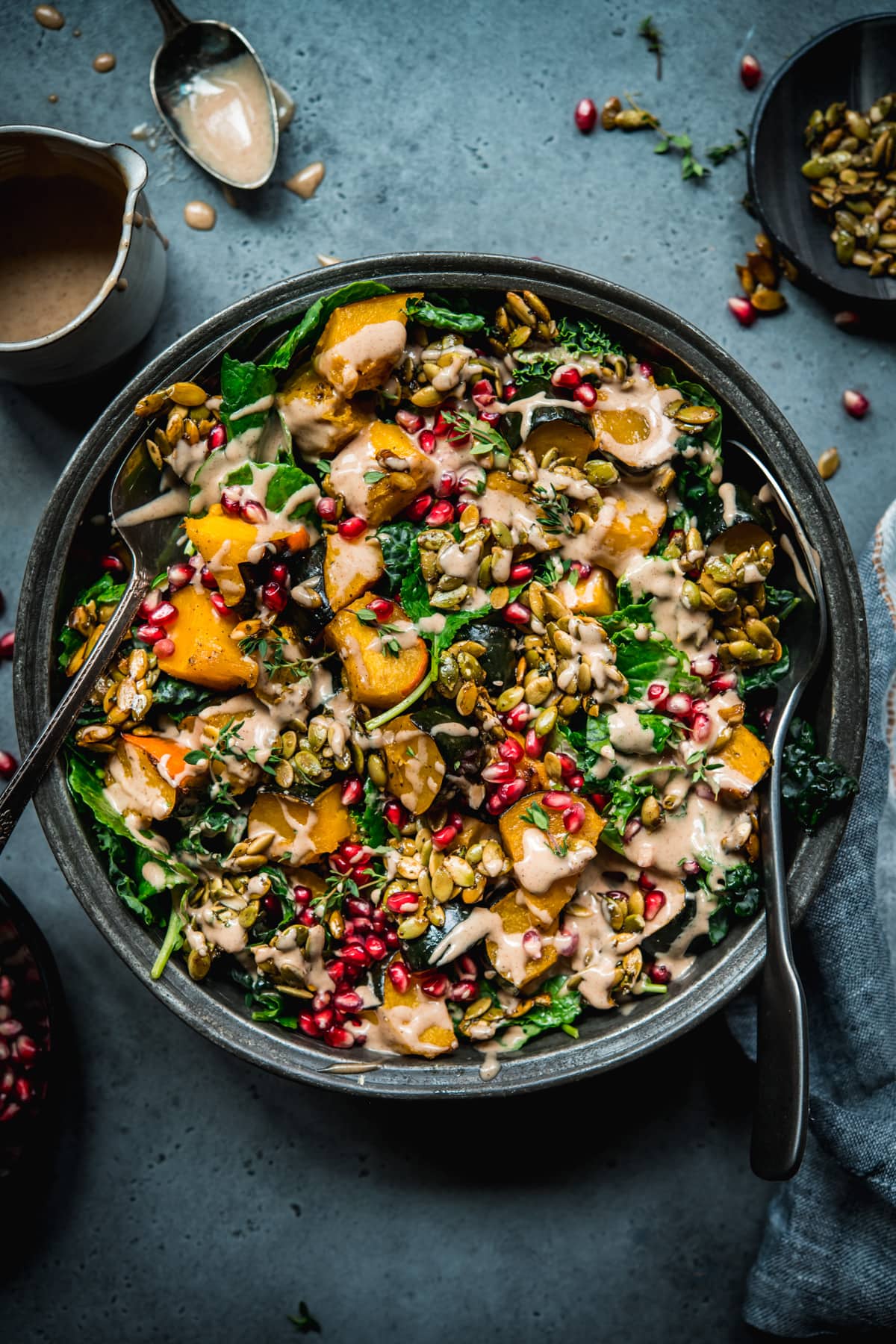 overhead view of roasted acorn squash salad with pumpkin seed brittle and tahini dressing.