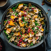 overhead view of roasted acorn squash salad with pumpkin seed brittle and tahini dressing.