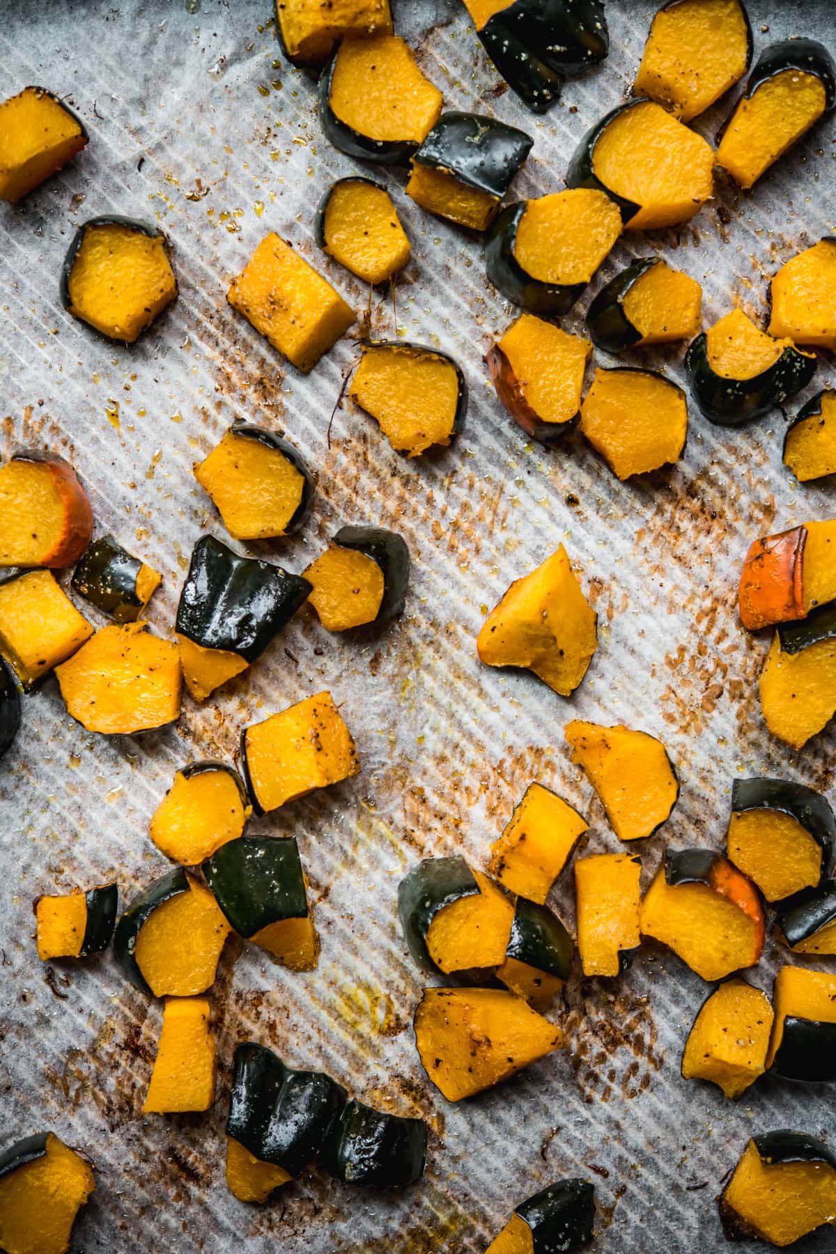 overhead view of roasted acorn squash on a sheet pan. 