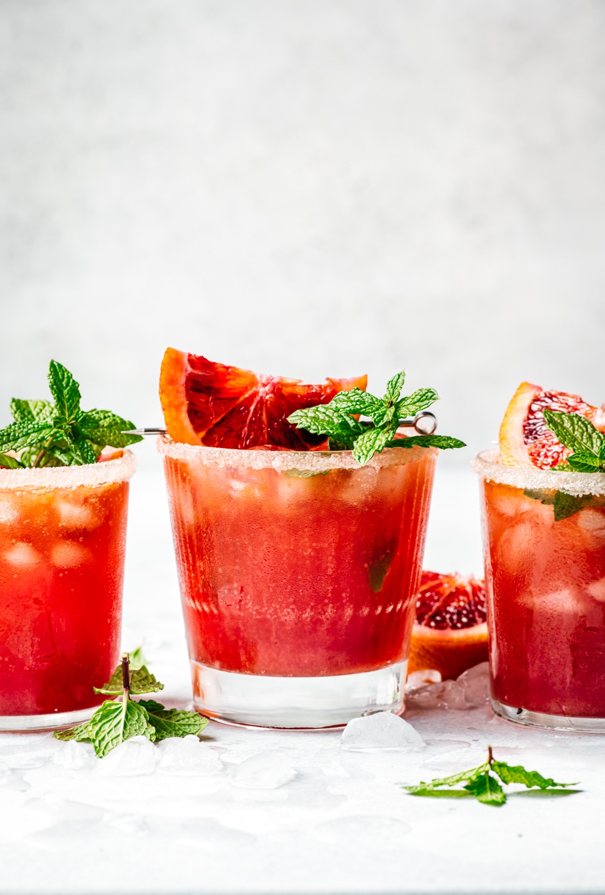 side view of blood orange kombucha margarita garnished with blood orange slice and fresh lime.