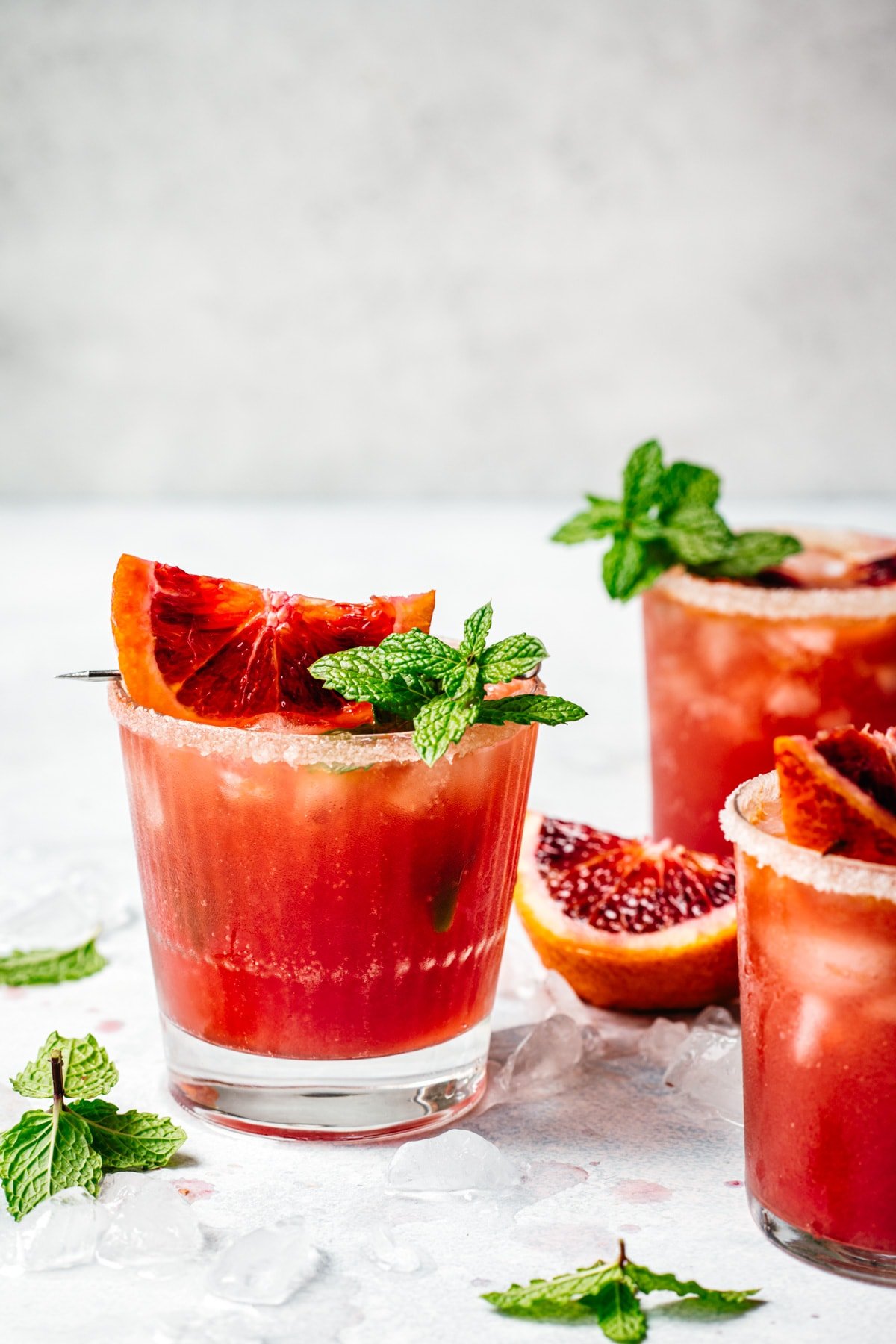 side view of blood orange kombucha margarita garnished with blood orange slice and fresh lime.