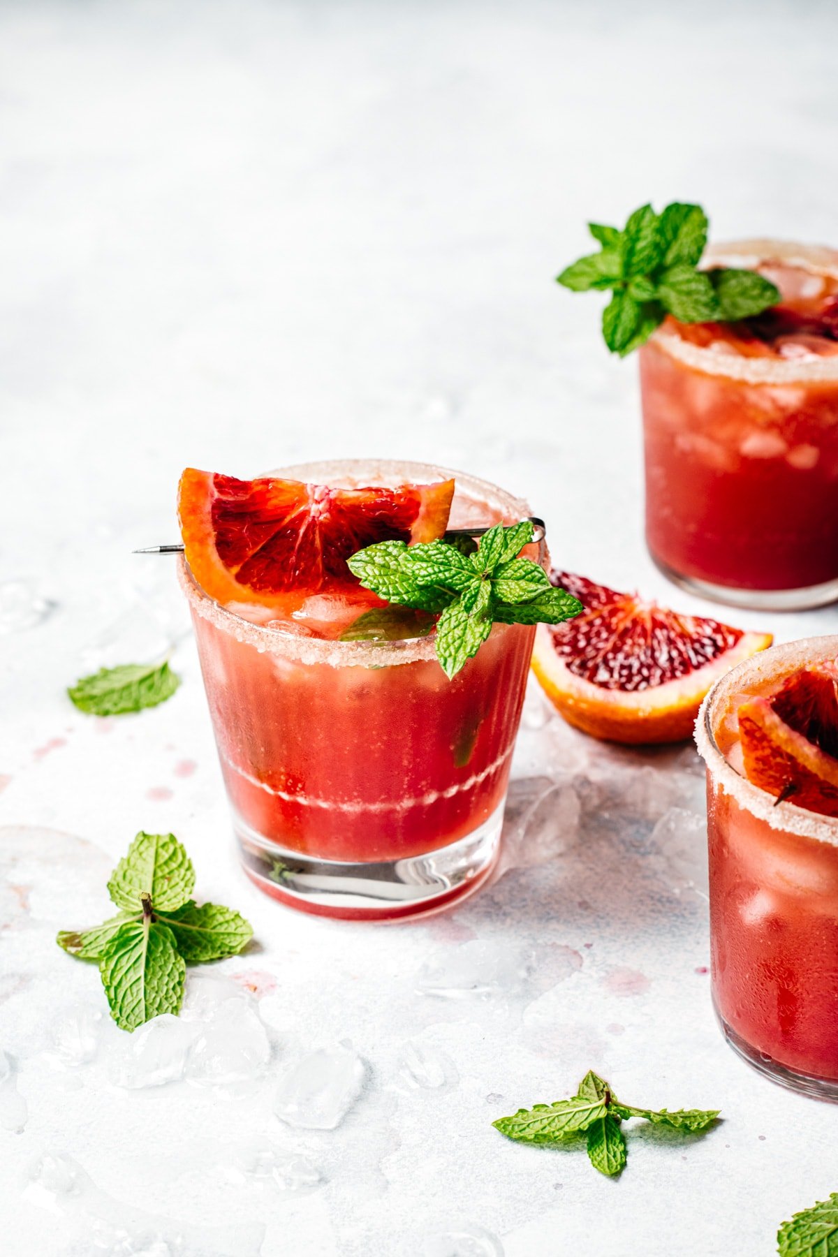 side view of blood orange kombucha margarita garnished with blood orange slice and fresh lime.