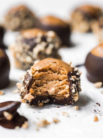 side view of vegan peanut butter buckeye with bite taken out.