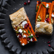 close up view of two slices of carrot tart on a black plate.