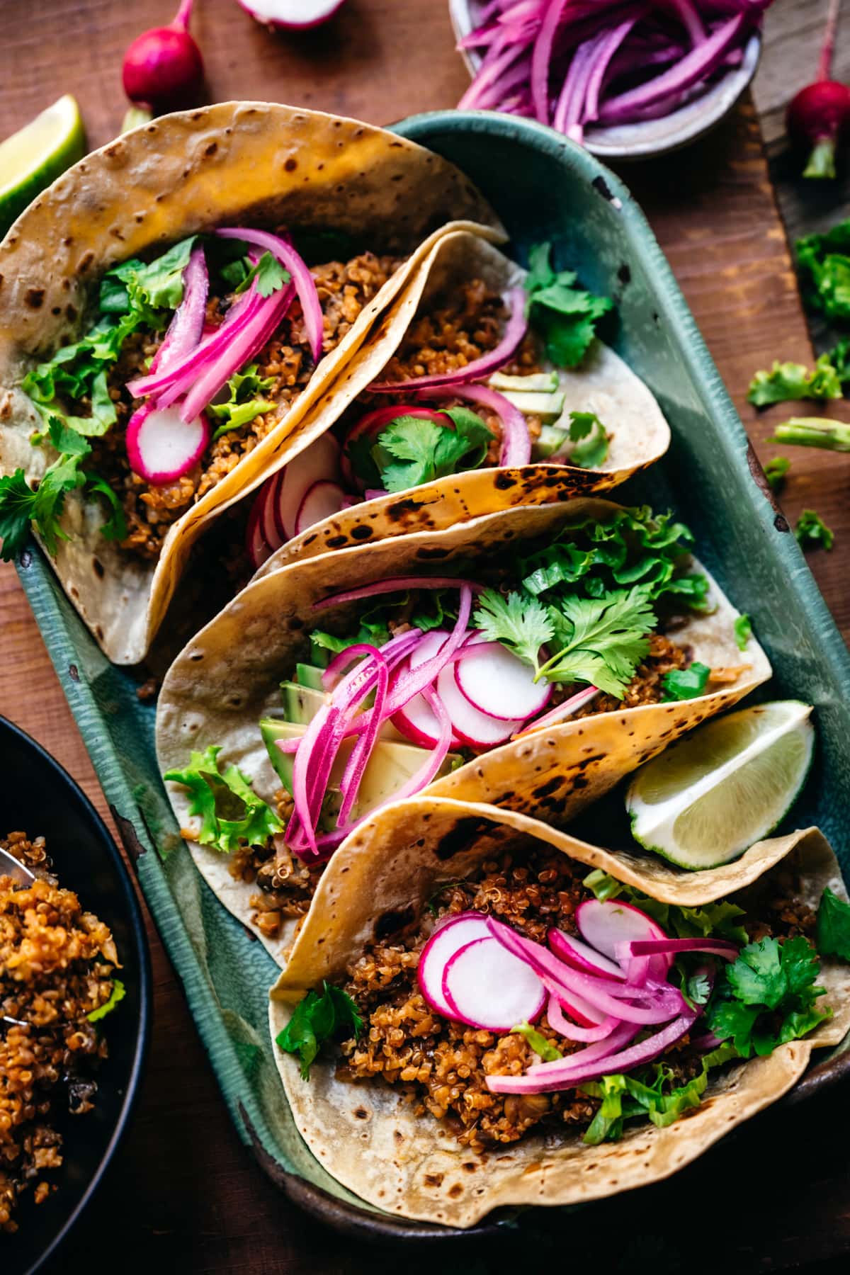 close up view of tacos with vegan cauliflower quinoa taco meat and pickled onion. 