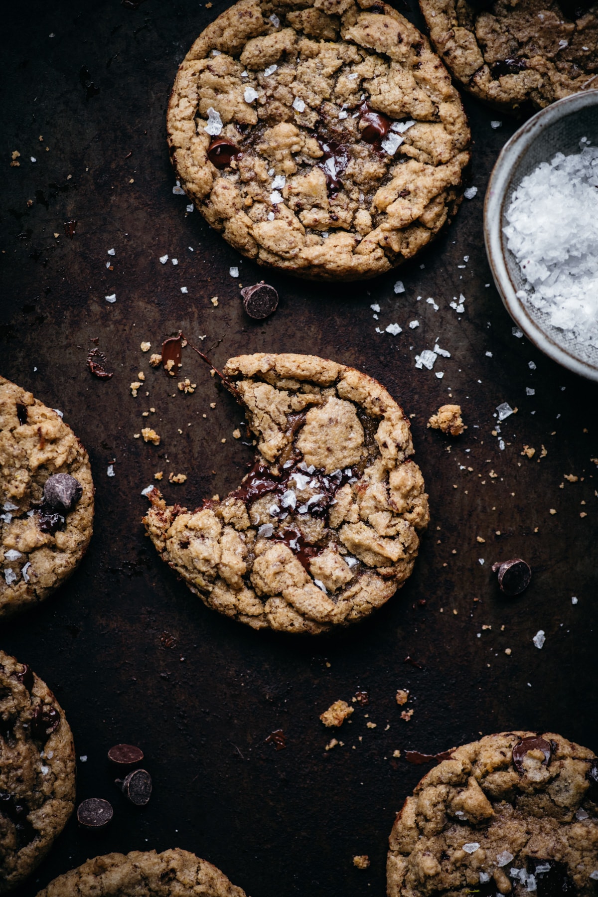 close up view of freshly baked soft and chewy chocolate chip cookie with bite taken out. 