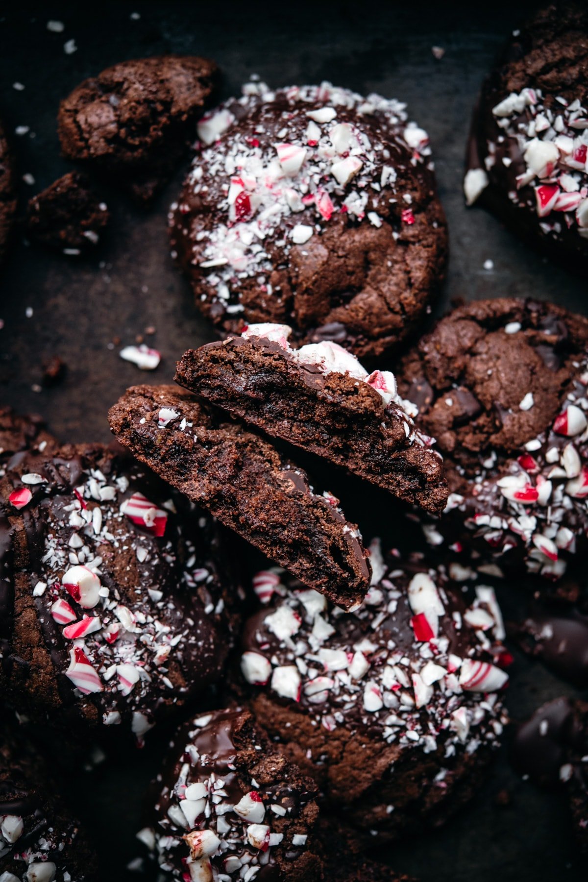 close up view of double chocolate peppermint cookie broken in half. 