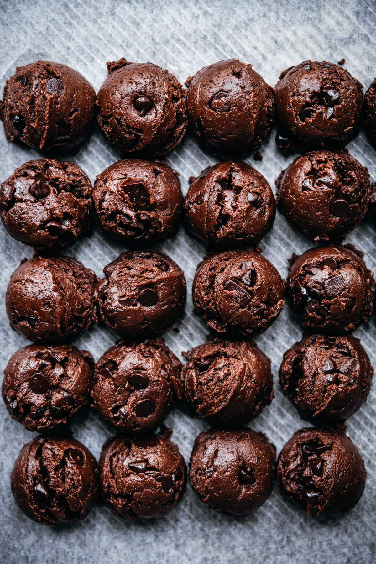 close up overhead view of vegan double chocolate cookie dough balls on parchment paper.