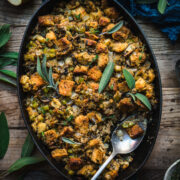 close up overhead view of gluten free vegan stuffing in a pan with fresh sage on top.