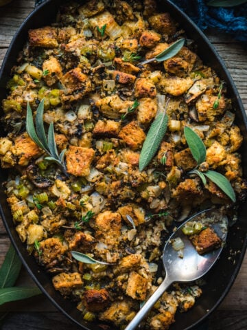 close up overhead view of gluten free vegan stuffing in a pan with fresh sage on top.