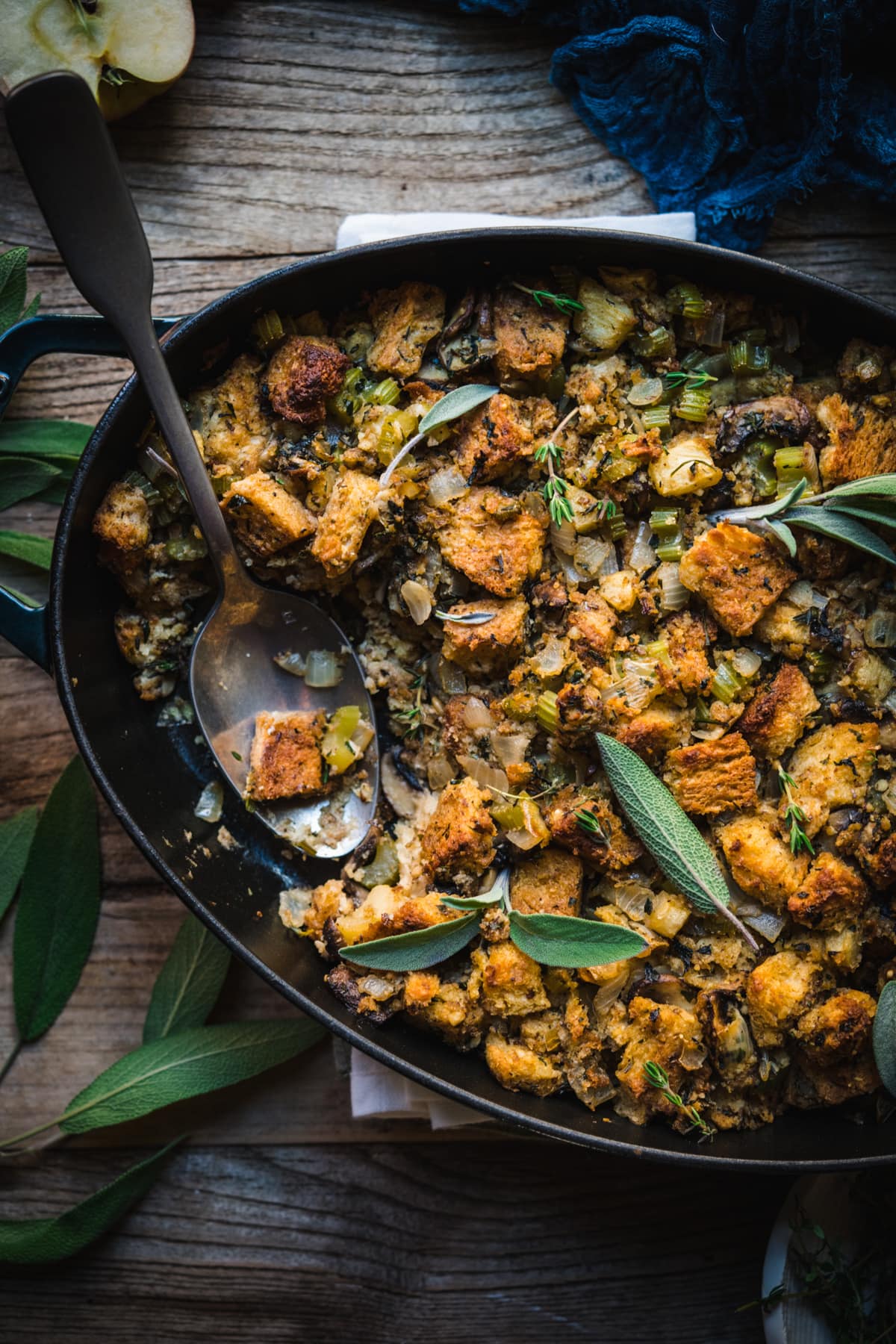 overhead view of gluten free vegan stuffing in an oval pan with serving spoon. 