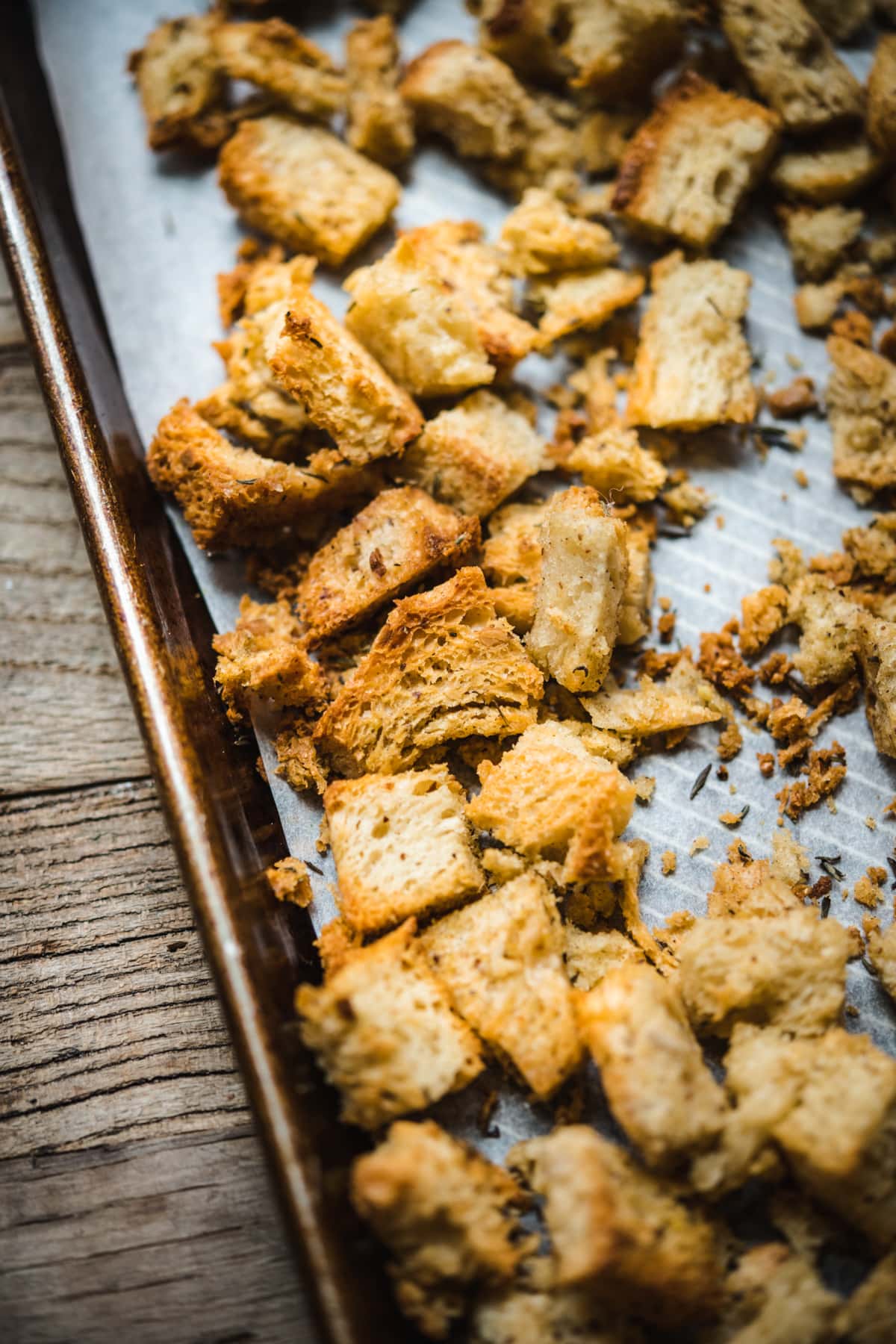 close up view of toasted bread cubes on a sheet pan. 