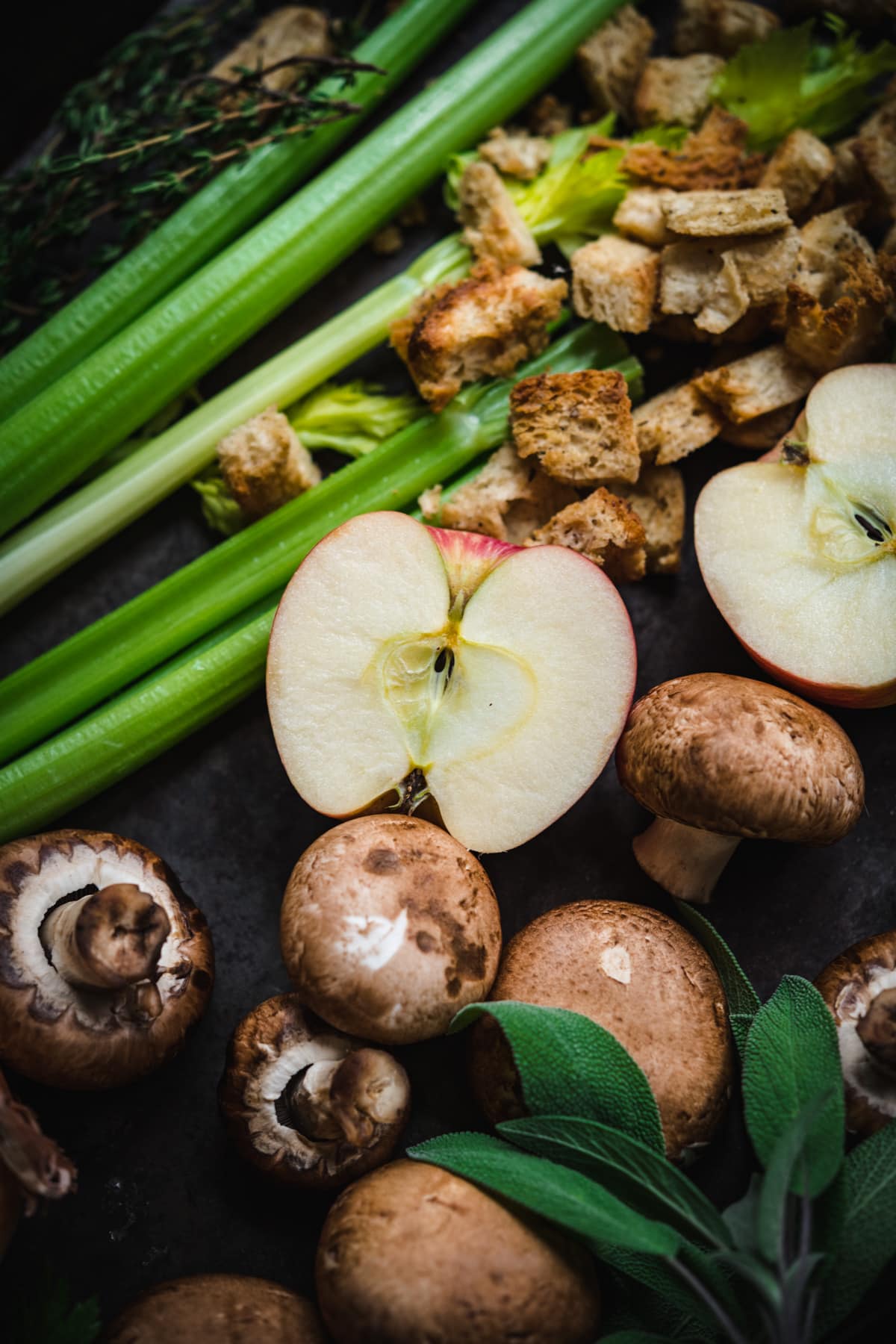 close up view of apple sliced in half surrounded by other ingredients for homemade stuffing. 