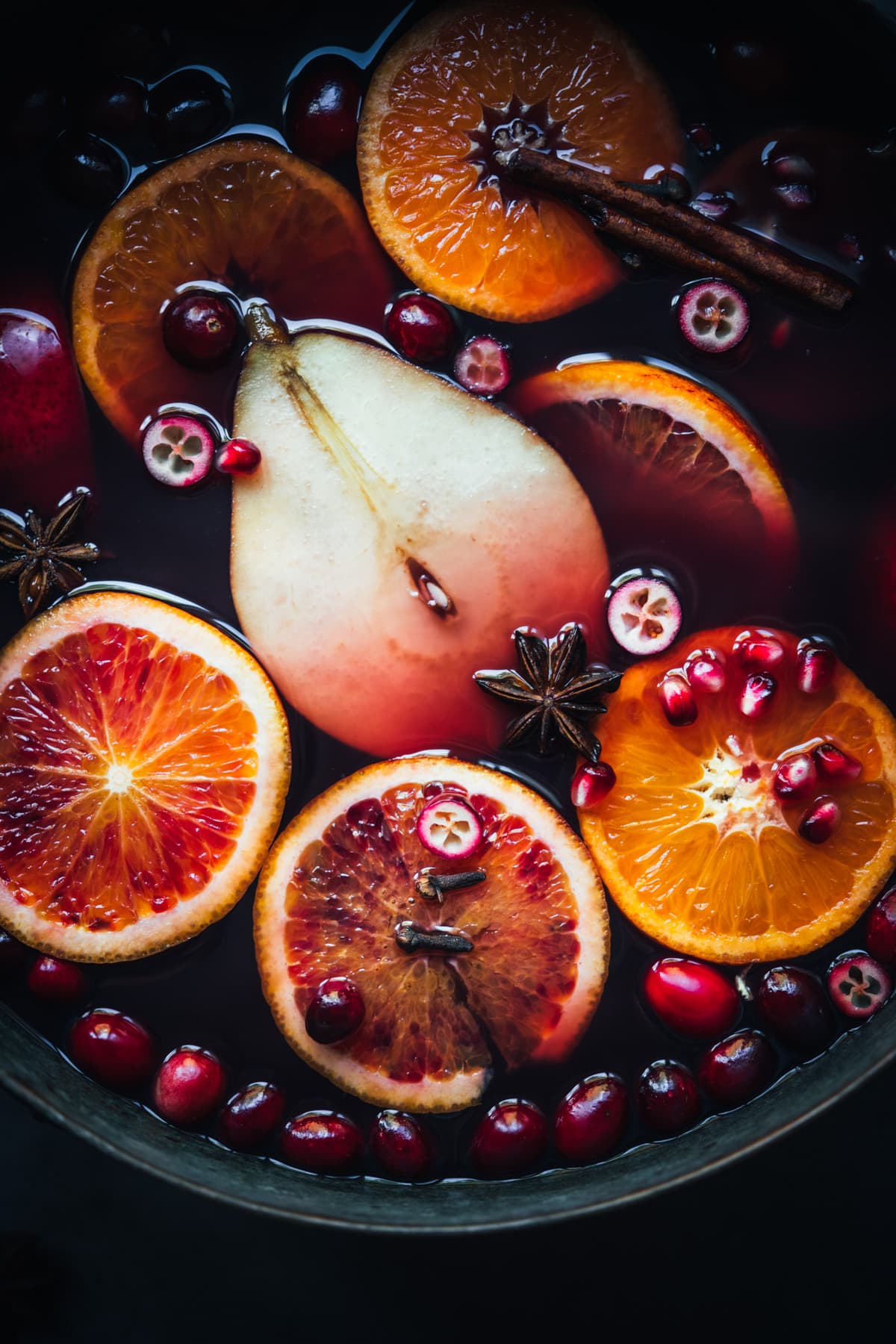 close up view of fruits and spices in mulled wine in pot. 