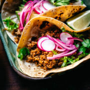 close up view of taco with vegan cauliflower quinoa taco meat and pickled onion.