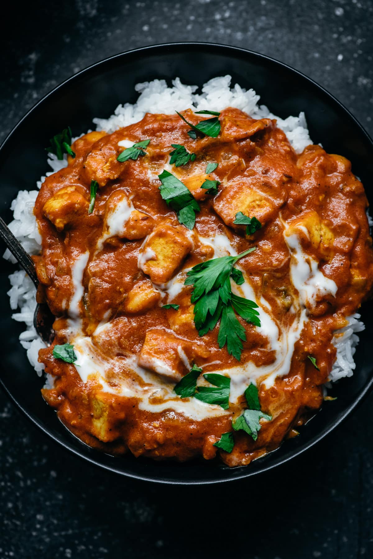 overhead view of vegan tofu tikka masala in a bowl with white rice. 