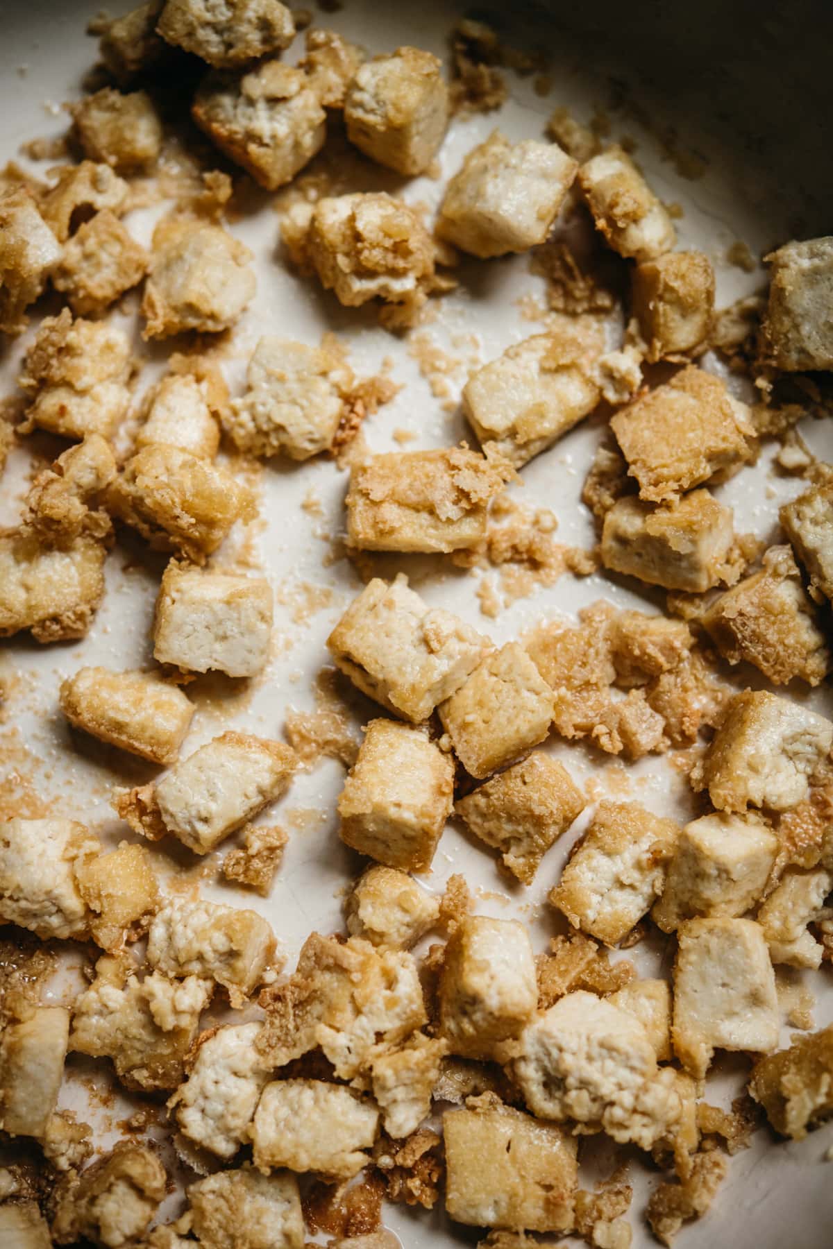 close up view of crispy pan-fried tofu in a pan. 