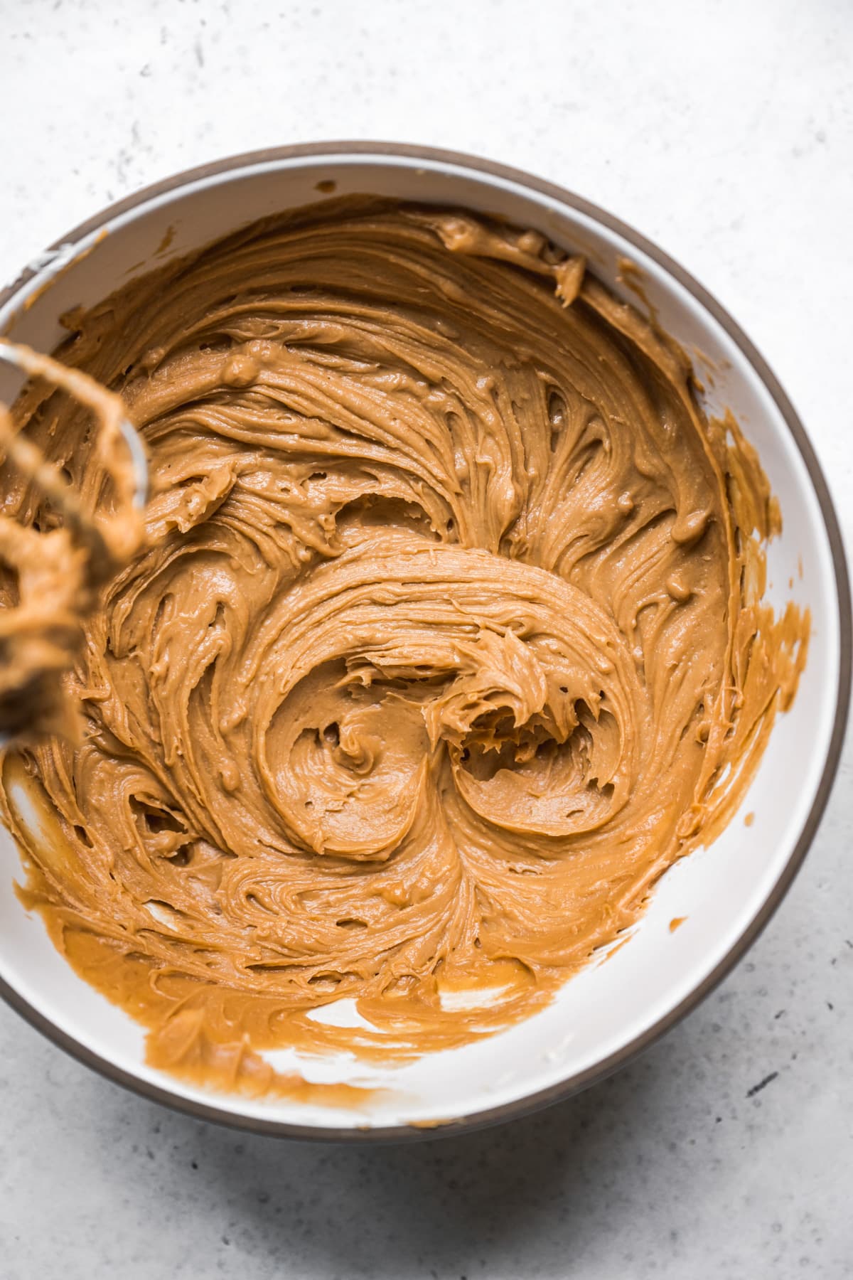 overhead view of vegan butter and peanut butter in mixing bowl. 