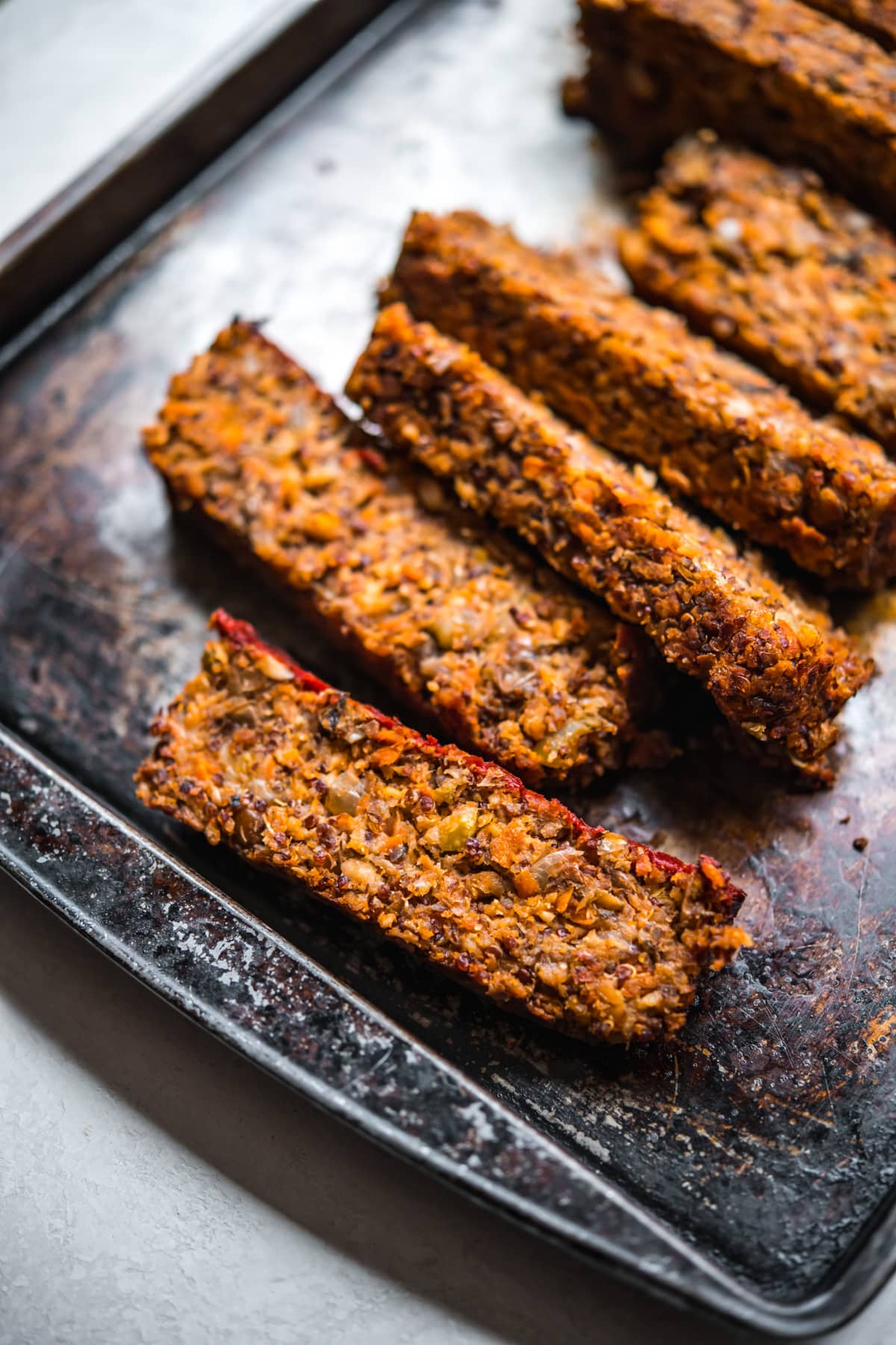 close up view of slices of vegan meatloaf on a sheet pan. 