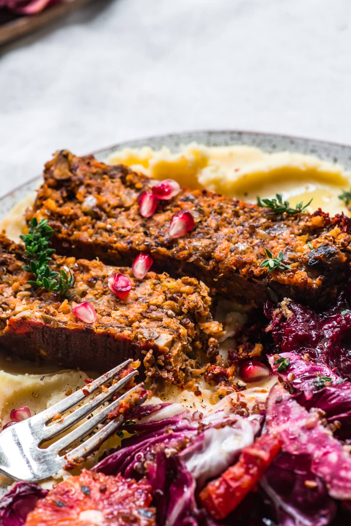 close up view of two slices of vegan lentil quinoa meatloaf on a plate. 