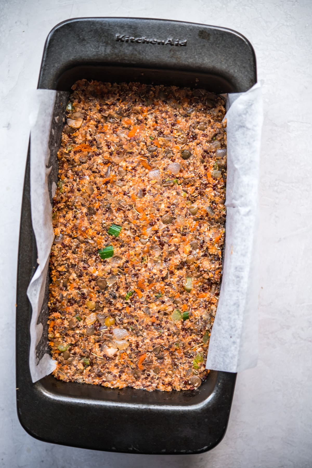 Vegan meatloaf pressed into a loaf pan before baking. 