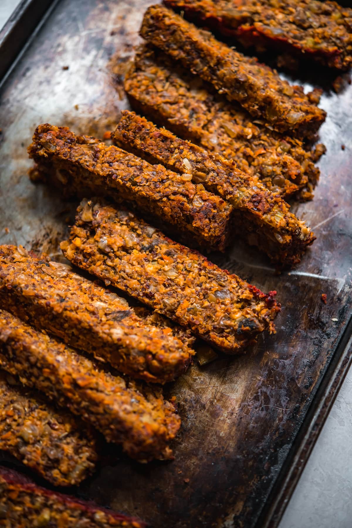 close up view of slices of vegan meatloaf on a sheet pan. 