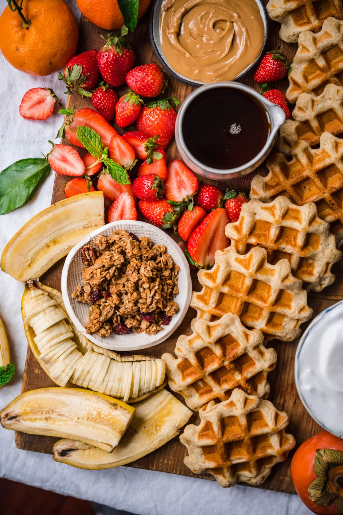 overhead view of waffle board with granola, fruit and bananas.