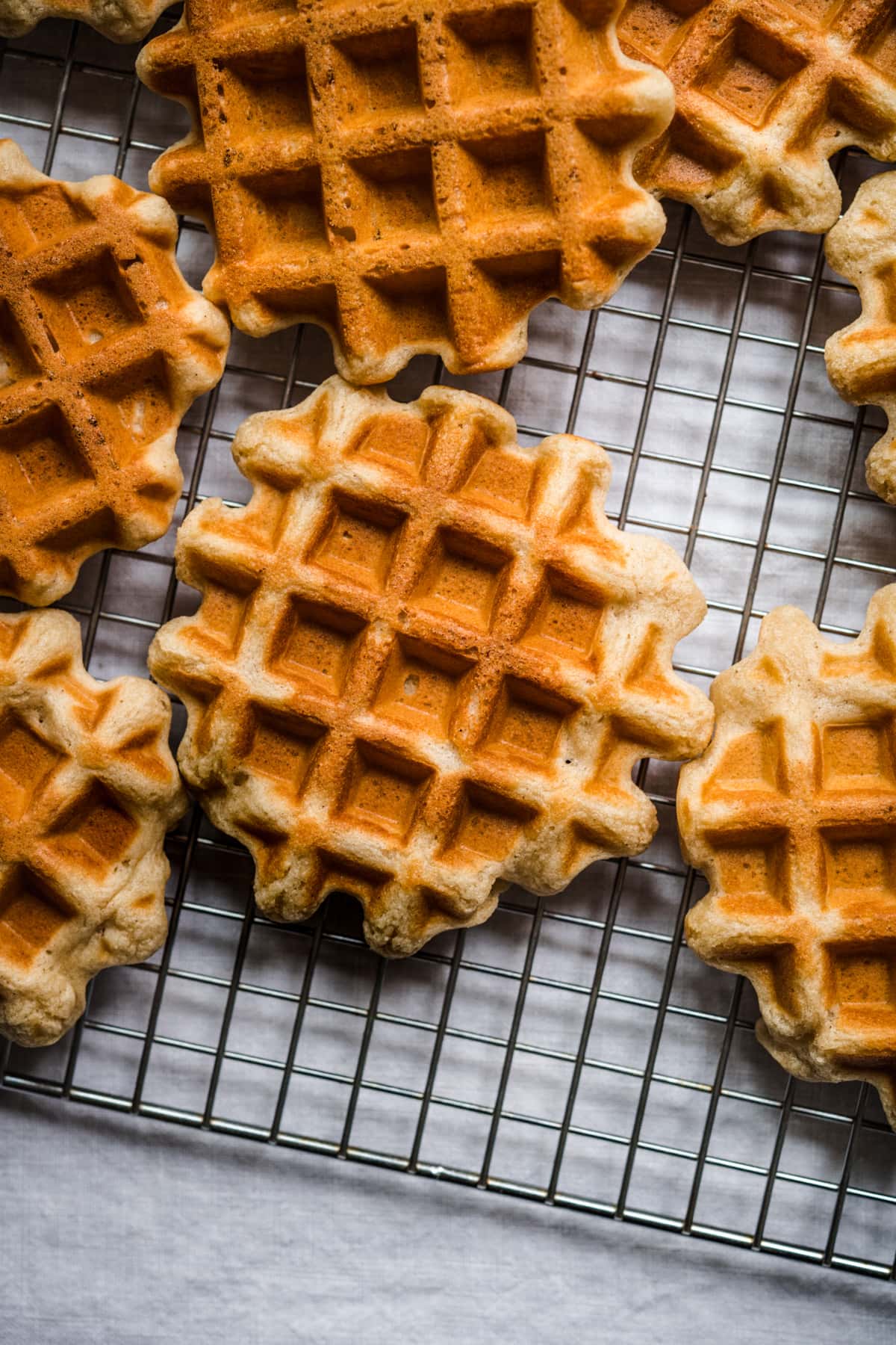 overhead view of homemade waffles on cooling rack.