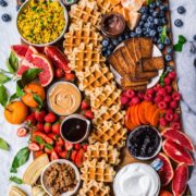 overhead view of loaded build your own waffle board with homemade waffles, fruit and toppings.