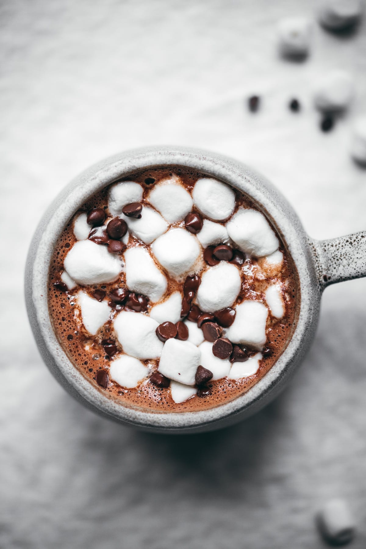 close up view of vegan hot chocolate with mini marshmallows and chocolate chips.