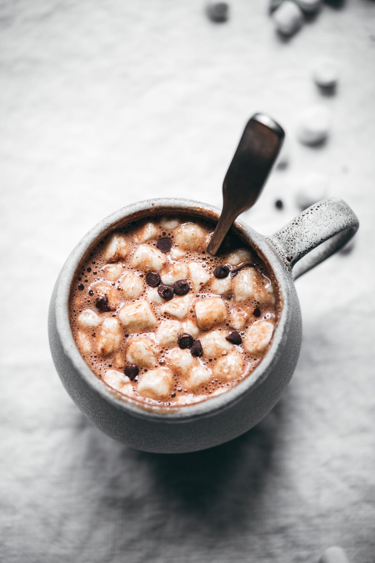 close up view of vegan hot chocolate with mini marshmallows and chocolate chips.