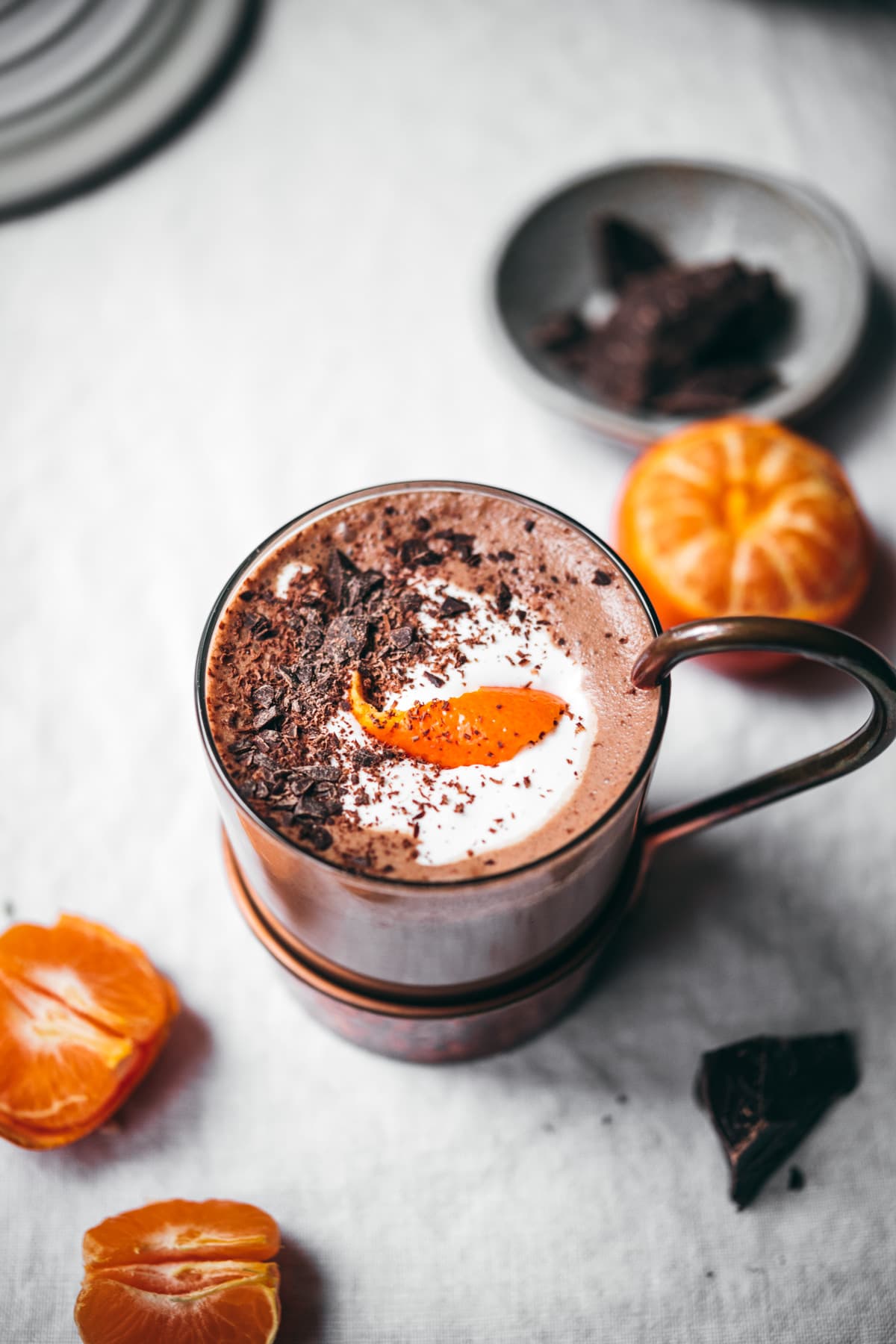 close up view of vegan bourbon orange hot chocolate topped with chocolate shavings and orange peel. 