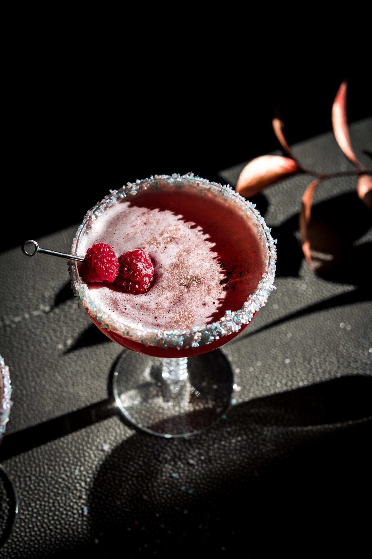 shimmery santa baby cocktail garnished with fresh raspberries. 