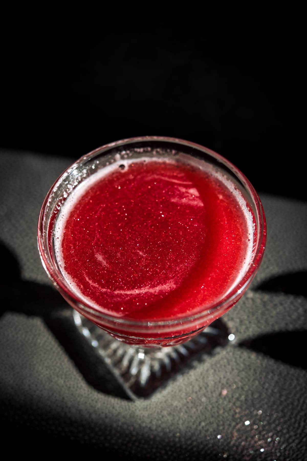 close up view of shimmery raspberry rosé cocktail.
