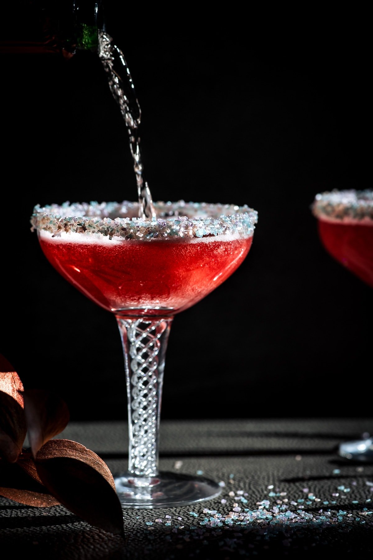 close up side view of pouring champagne into santa baby cocktail.