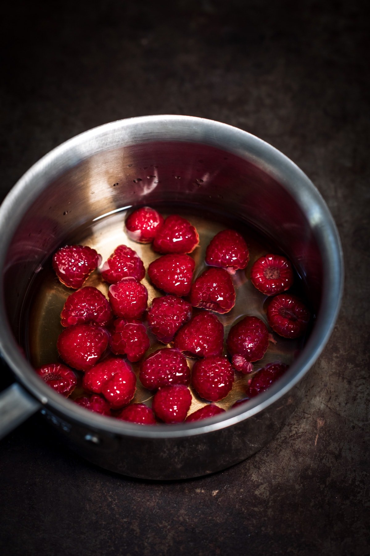 close up view of raspberry simple syrup in pot. 