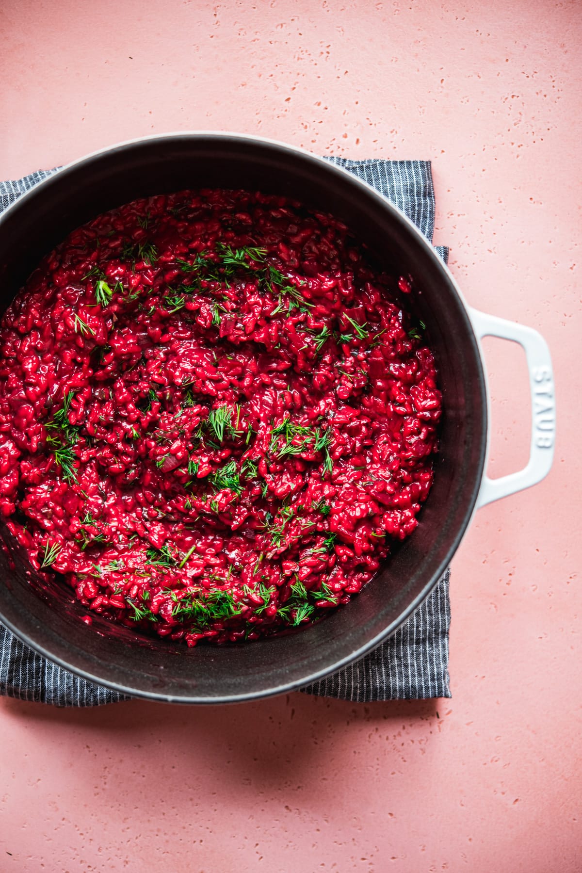 Overhead view of vegan beet risotto in a large white pot. 