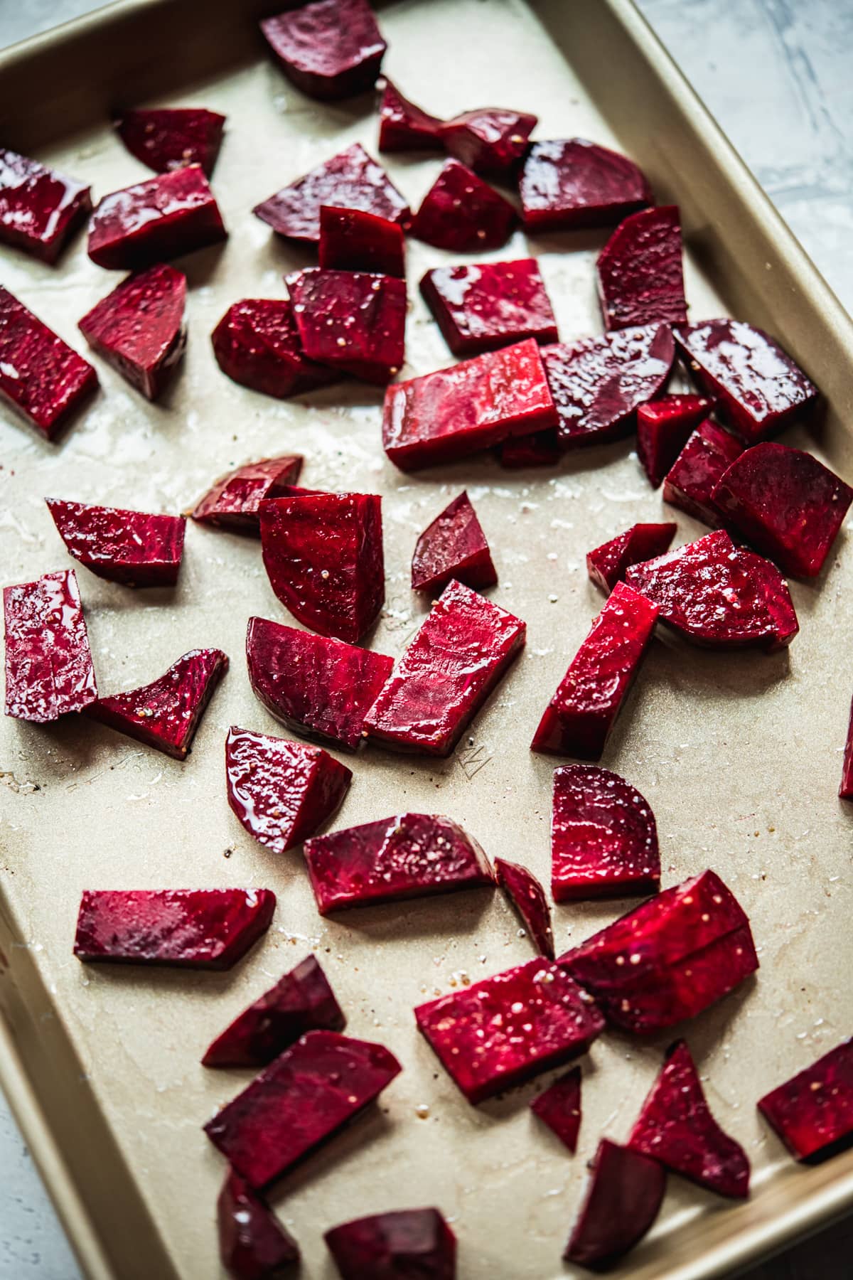 close up view of diced beets on sheet pan before roasting. 