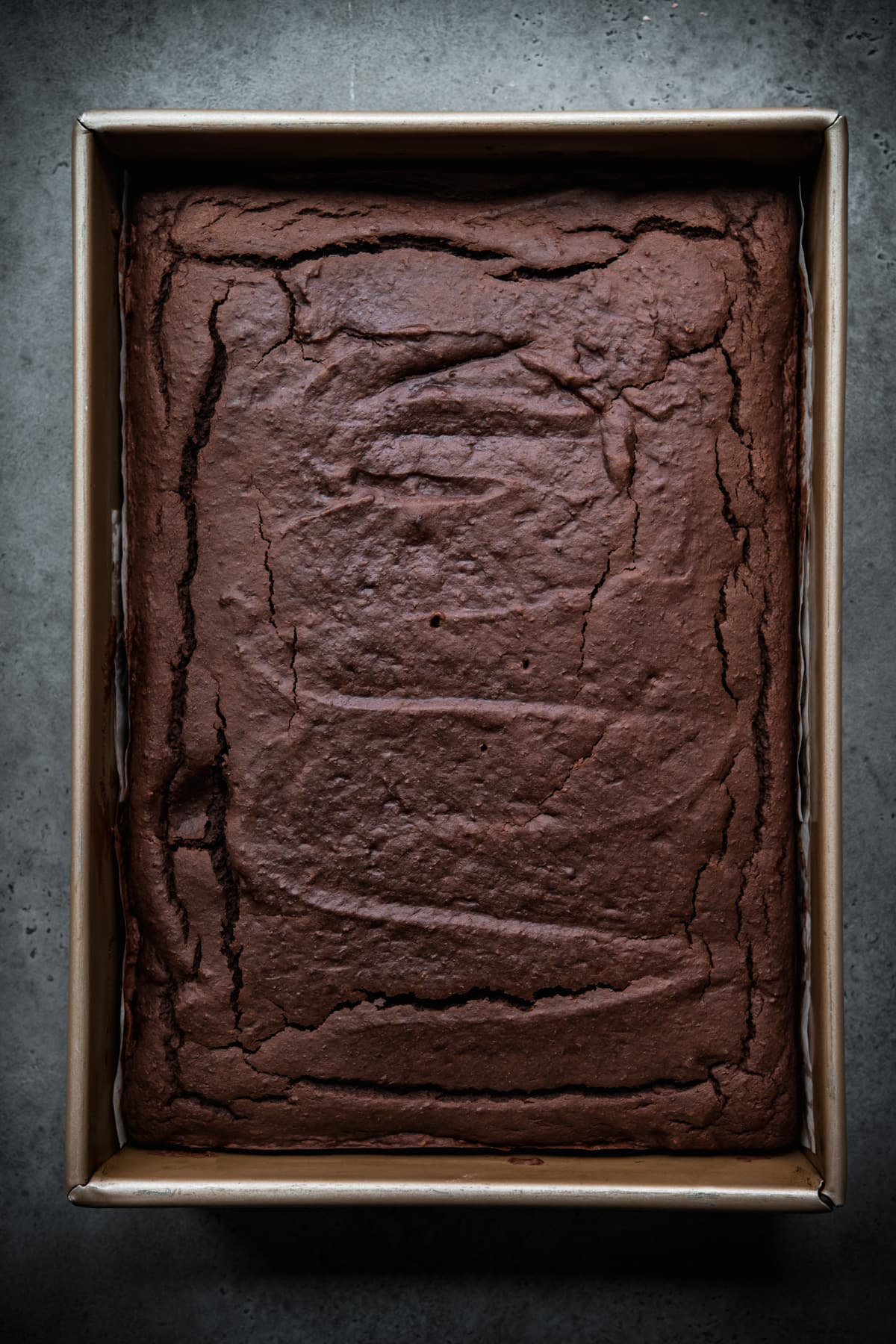 overhead view of baked vegan gluten free chocolate cake in a pan. 