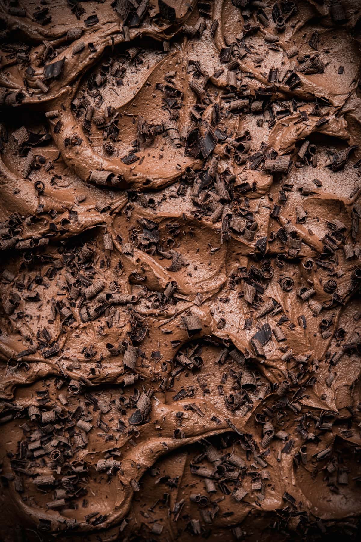 close up view of vegan gluten free chocolate cake with chocolate shavings. 