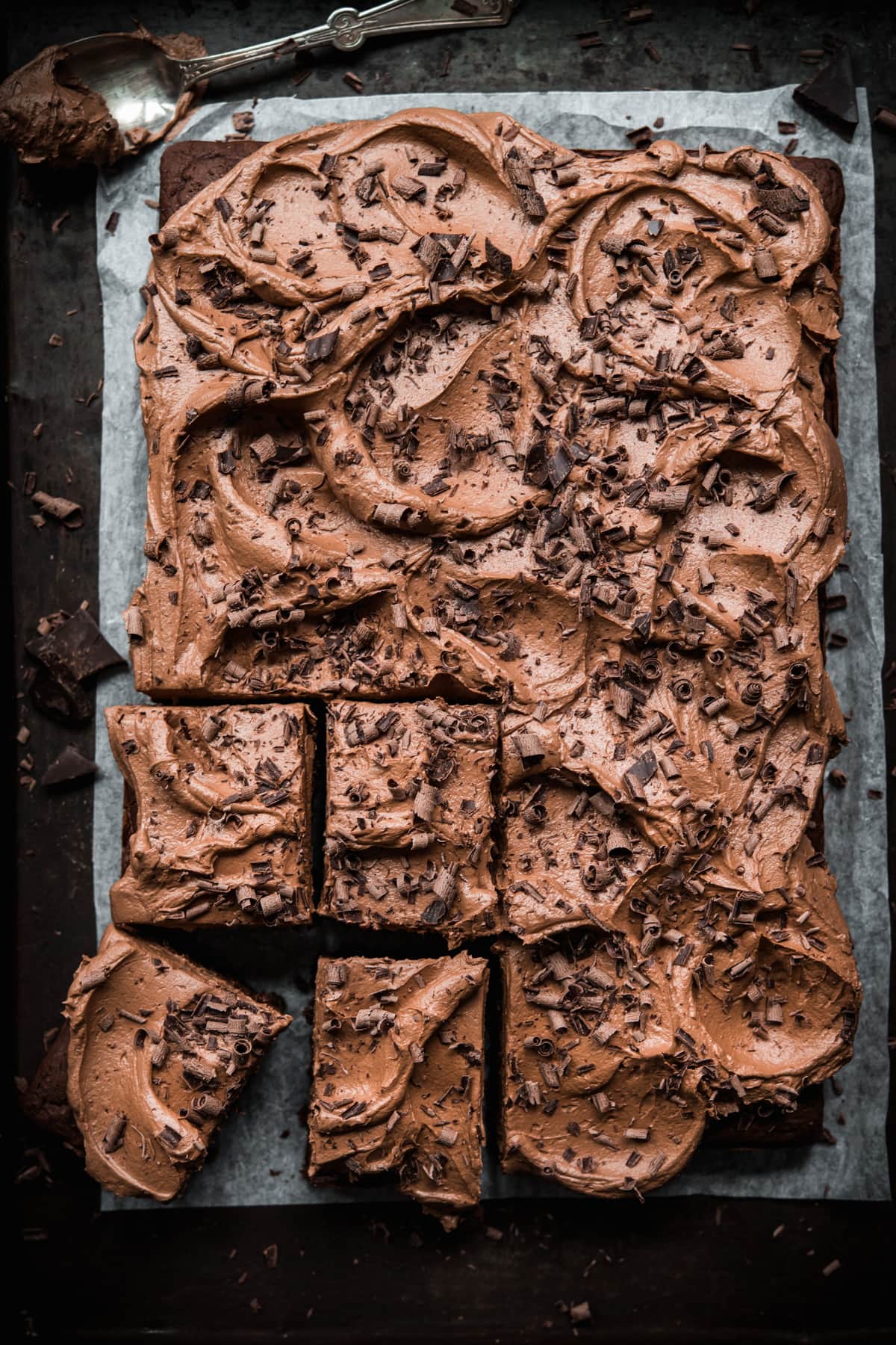 overhead view of sliced vegan gluten free chocolate cake with chocolate shavings. 