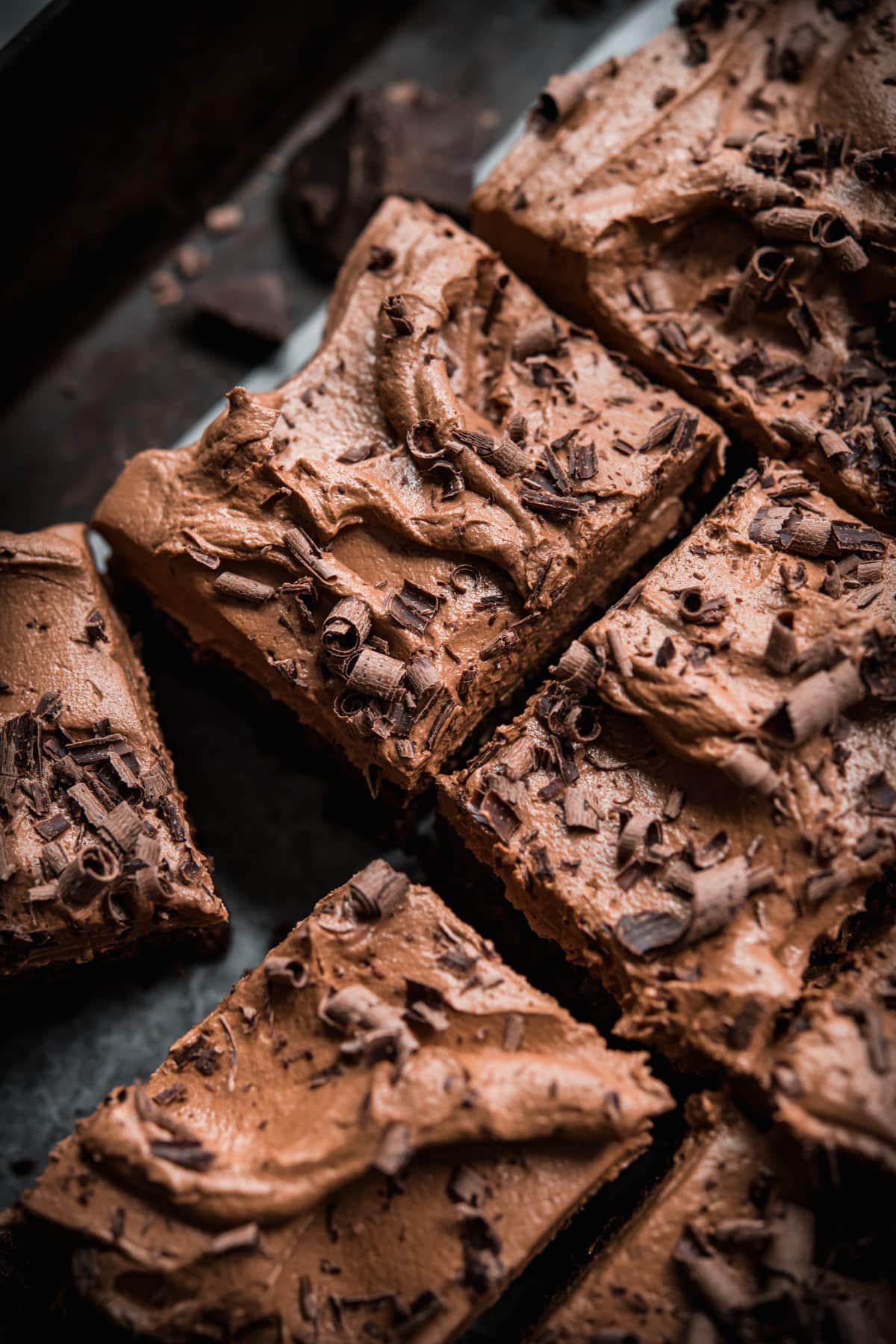 close up view of sliced vegan gluten free chocolate cake with chocolate shavings. 