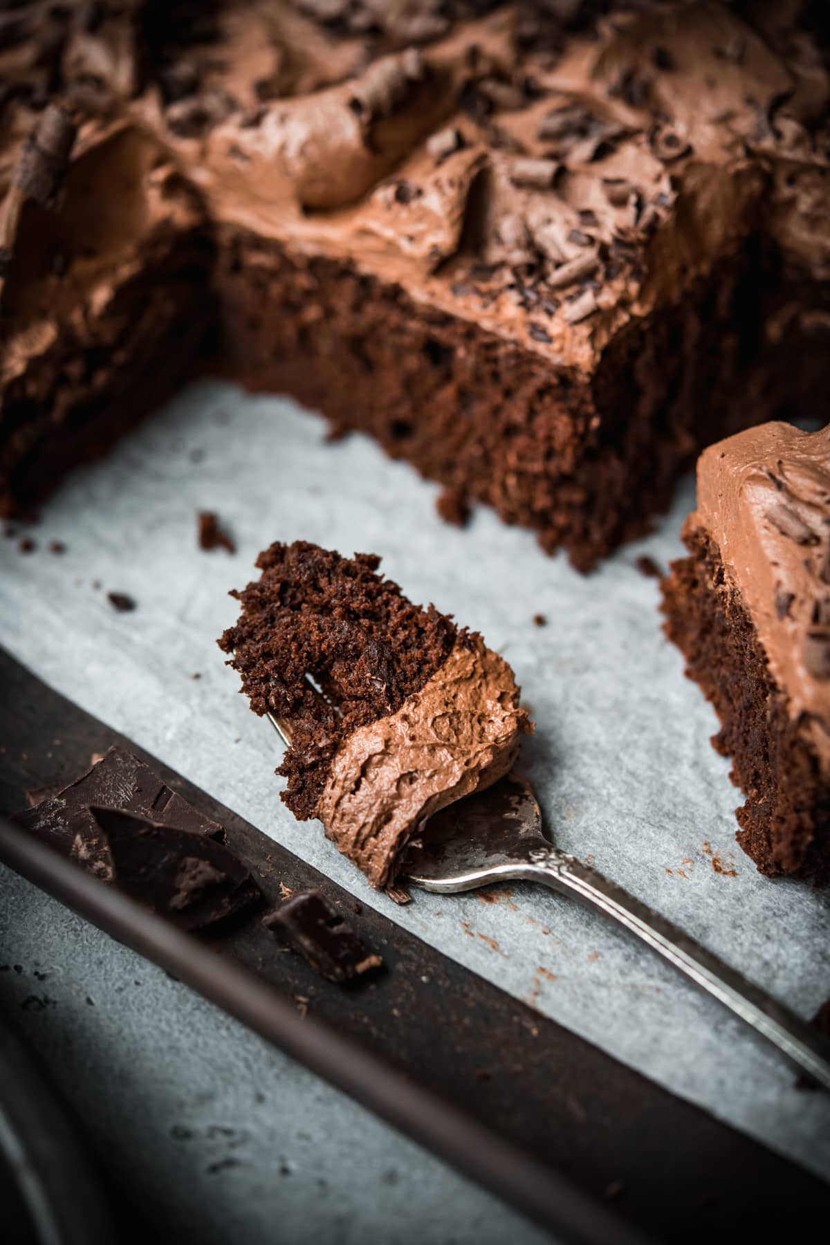 closeup view of vegan chocolate cake and buttercream on a fork. 