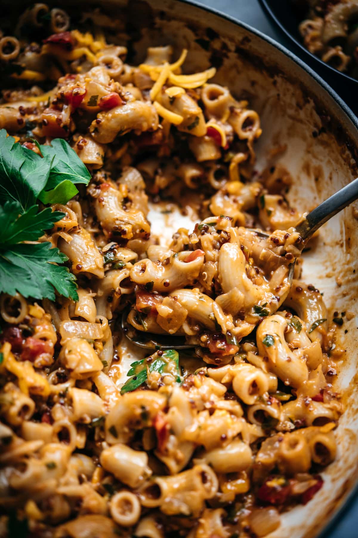 close up view of vegan hamburger helper in a pan with serving spoon.